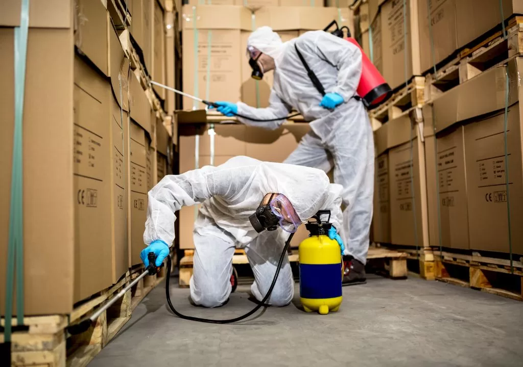 Pekerja industri kimia mengenakan penuh alat pelindung diri (APD)